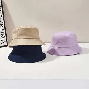 Detailed view of stitching on cotton fisherman hats in khaki, navy, and lavender tones