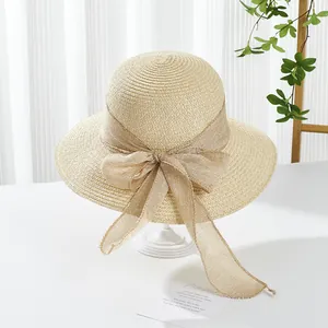 Close-up of woven straw sun hat featuring a large elegant linen bow decoration
