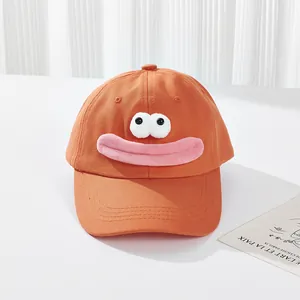 Detail einer süßen orangefarbenen Baseballkappe mit 3D-Augen und rosa Wurstmund