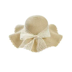 Women's summer straw sun hat with large wavy brim and white lace bow detail
