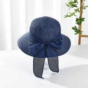 Close-up of navy blue straw sun hat featuring a large elegant mesh bow detail