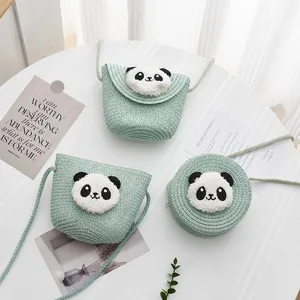 Detalle de bolsos de paja verde menta con panda de peluche 3D y correa larga tejida