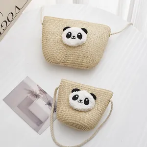 Dettaglio di borse in paglia intrecciata a forma di panda in due dimensioni e tracolla