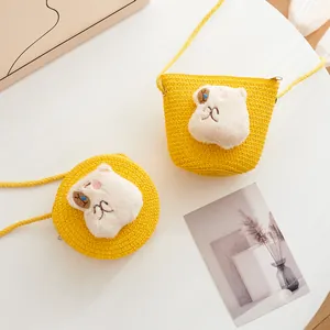 Detailed view of yellow woven straw crossbody bags with cute 3D cartoon animal character