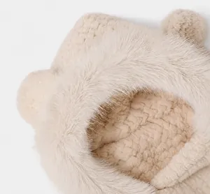 Gros plan détaillé sur la texture pelucheuse et les oreilles d'ours 3D de ce bonnet d'hiver beige