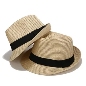 Detailed macro view of beige straw fedora hats with black ribbon and woven texture