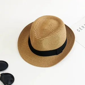 Summer straw fedora hat with black ribbon for sun protection, travel style with magazine