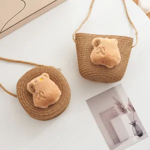Straw-woven crossbody bags for kids featuring cute plush bear heads in a macro shot