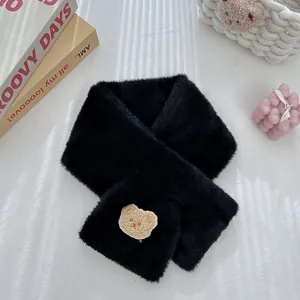 Detailed close-up of a black plush scarf with cute bear embroidery on white texture