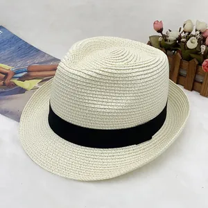 Detailed view of beige straw sun hat with black ribbon and fine woven natural texture