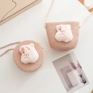 Detailed view of pink woven straw crossbody bags for kids with plush animal decor