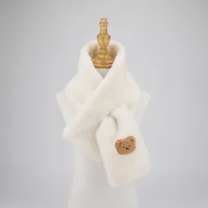 Detail of plush cream faux fur scarf with cute brown bear embroidery and crossover design