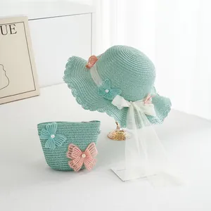 Detail of mint green straw hat and bag set with lace butterflies and pearl accents
