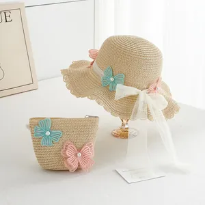Detail of girls straw sun hat and matching bag with lace butterflies and pearls