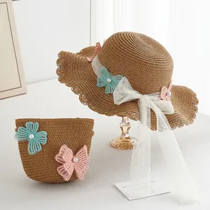 Detail of straw hat and matching bag set with lace butterflies and pearl accents