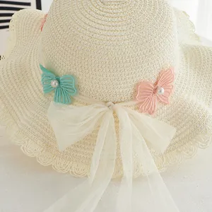 Detailed shot of girls straw hat with embroidered butterflies and white mesh bow