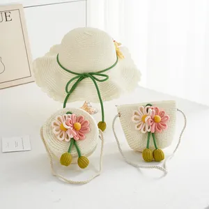 Detail of cream straw sun hat and matching crossbody bags with woven floral accents