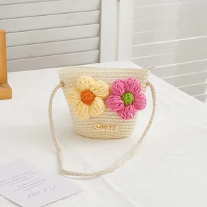 Detailed view of beige straw bucket bag with crochet flowers and Sweet embroidery text