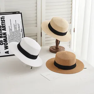 Elegant summer straw boater hats in white, beige, and brown with black ribbons for sun protection