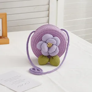 Close-up of a purple woven straw bag featuring a delicate 3D fabric flower and leaf detail