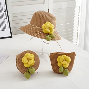 Détail d'un chapeau de paille et de sacs tissés avec des fleurs en tissu jaune et vert
