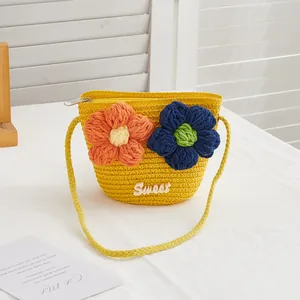Detail of yellow woven straw bag with handmade knit flowers and Sweet lettering