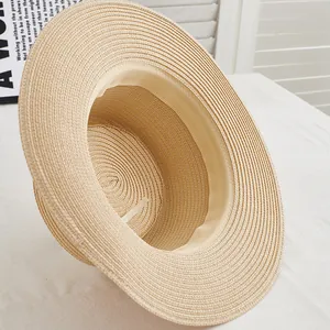 Detailed macro view of beige straw hat featuring woven texture and inner adjustable drawstring