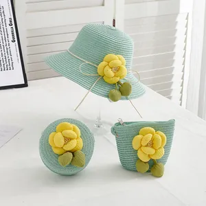Détail de chapeau et sacs en paille vert clair avec fleurs de camélia jaunes décoratives