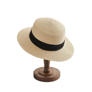 Classic summer straw boater hat with a wide black ribbon on a wooden display stand