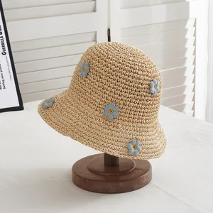Handgefertigter beige Strohhut mit Gänseblümchen auf Holzständer für Sonnenschutz