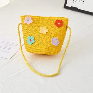 Detail von bunten Häkelblumen auf einer gelben geflochtenen Strohtasche für Mädchen
