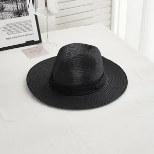 Close-up detail of woven texture and black decorative ribbon on summer straw jazz hat