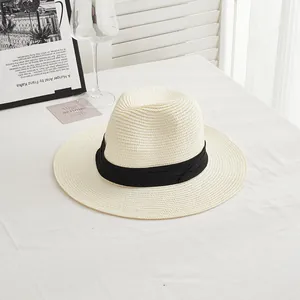 Close-up of cream straw Fedora hat featuring fine texture and black ribbon contrast