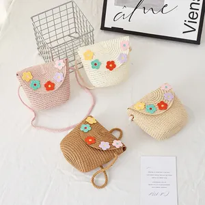 Flat lay of colorful handmade straw shoulder bags for kids with crochet flower decorations