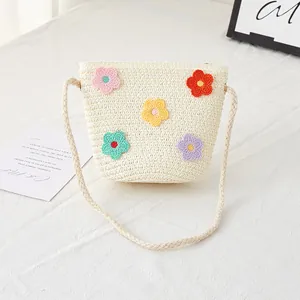 Detailansicht der Stroh-Eimertasche mit bunten Häkelblumen für Mädchen am Strand