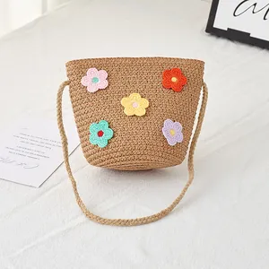 Detailansicht der handgefertigten Strohtasche mit bunten Häkelblumen und Trageriemen
