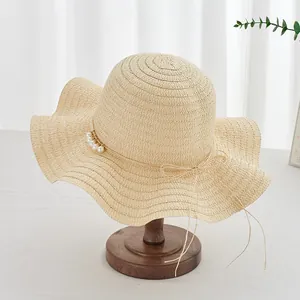 Chapeau de paille d'été pour femmes avec nœud perlé et large bord ondulé