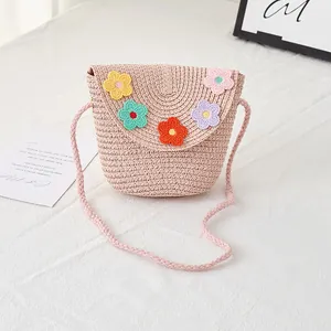 Detail of pink straw woven crossbody bag for girls with colorful crochet flowers