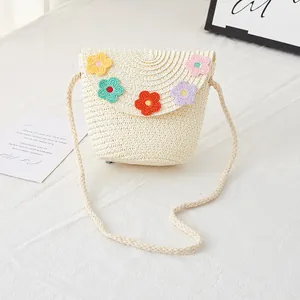 Detailed macro view of cream woven kids straw bag with colorful crochet flower accents