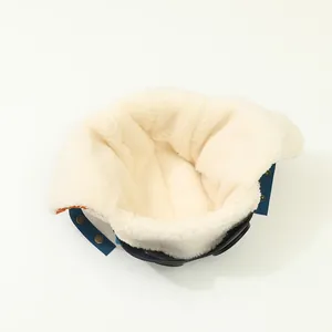 Détail de la doublure polaire blanche épaisse et du bouton pression du bonnet enfant