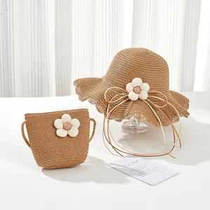 Detailed texture of straw sun hat and matching bag with white 3D floral accents