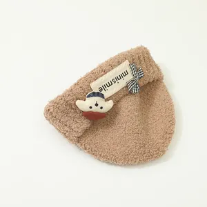 Dettaglio cappello neonato in peluche marrone con etichetta minismile e orsetto