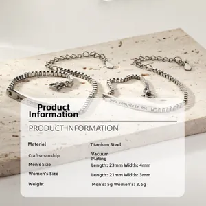 Détail de bracelets de couple en acier titane avec gravure You Complete Me et texture de chaîne
