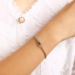 Détail du bracelet bolo argenté avec gravure 'you complete me' et chaîne ajustable