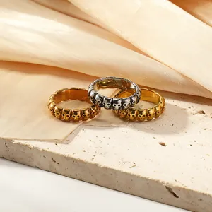 Anillos de calavera gótica en oro y plata sobre piedra texturizada y seda