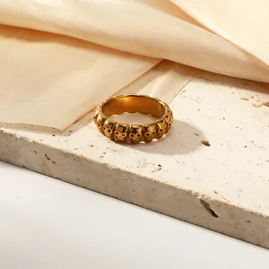 Primer plano detallado de anillo dorado con relieve de calaveras sobre seda