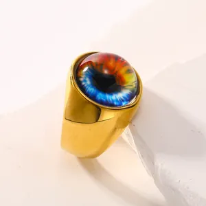 Bague oeil maléfique dorée à l'or 18 carats avec détails bleus sur un plateau en pierre