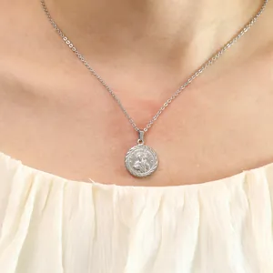 Detailed view of silver San Judas Tadeo religious coin pendant on a thin cross chain