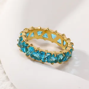 Détail de zircons bleus en cœur sertis sur un anneau en acier titane doré 18 carats