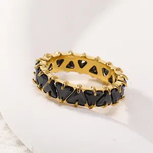 Détail macro d'une bague en titane plaqué or 18 carats avec pierres noires triangles